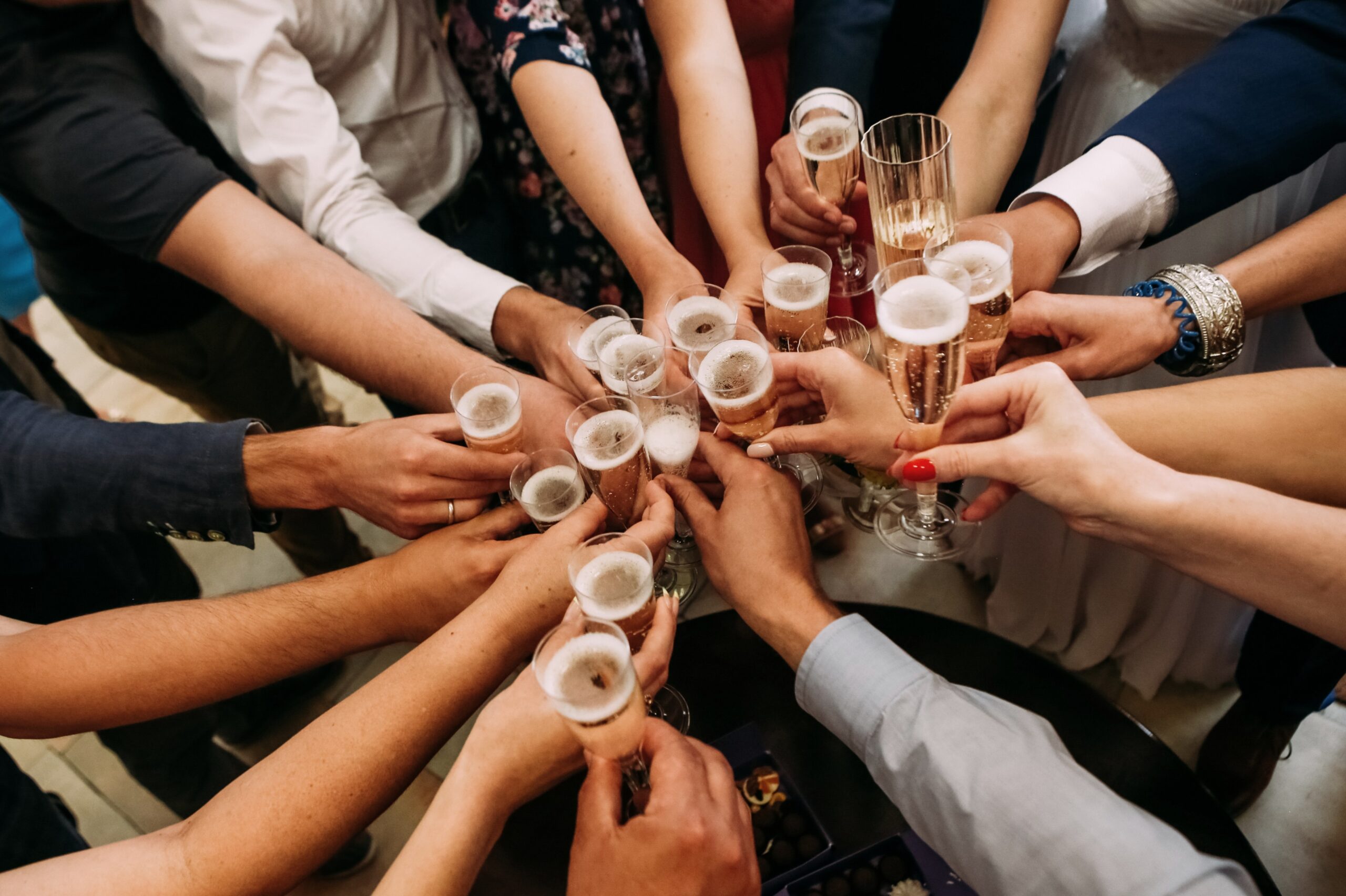 Multiple hands holding drinks, cheering and celebrating